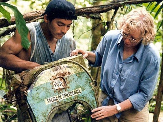 Juliane Koepcke with a guide looking at the wreck of a door