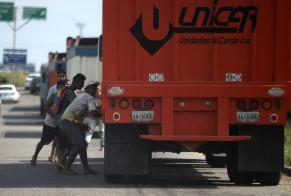 Men attempting to steal rice from a cargo truck