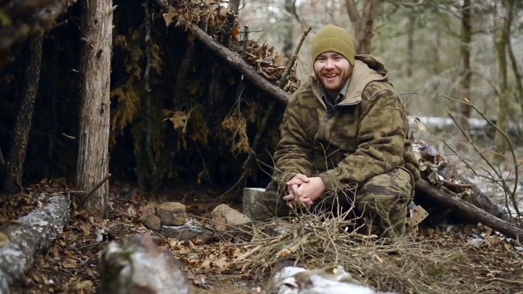Prepper in the woods smiling