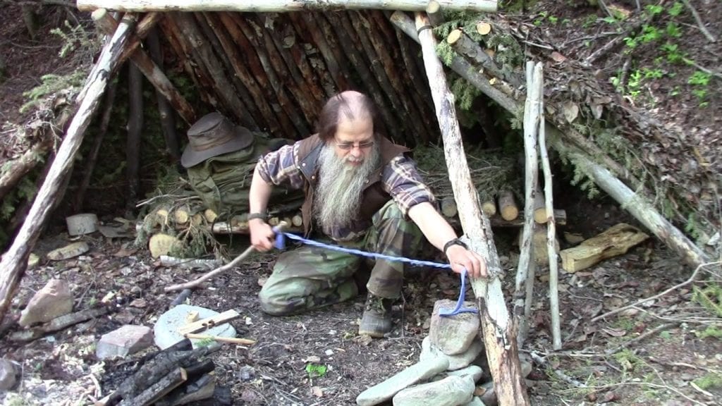 old man setting up a DIY tent