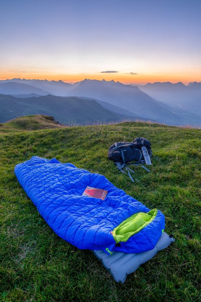 blue sleeping bag on mountain during daytime