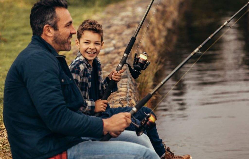 A kid and a man fishing together