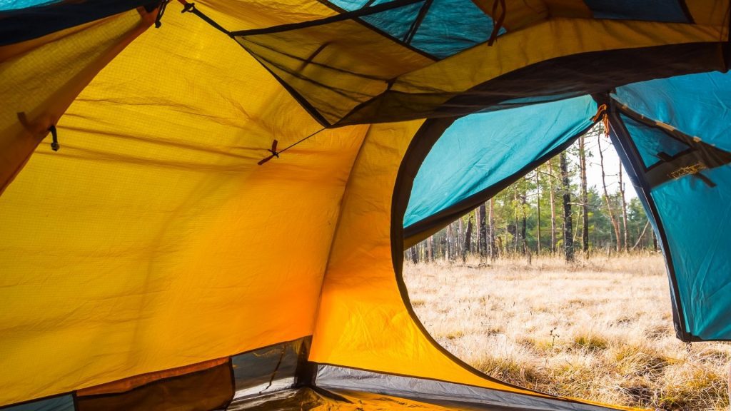 a yellow tent in a grassland