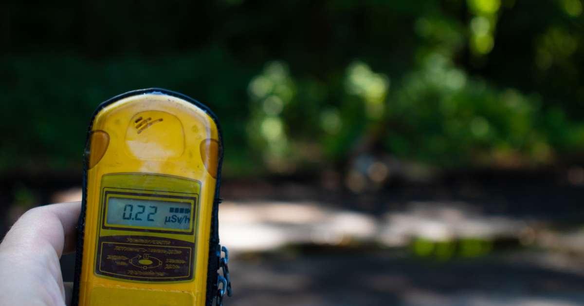 A hand holding a geiger counter. 