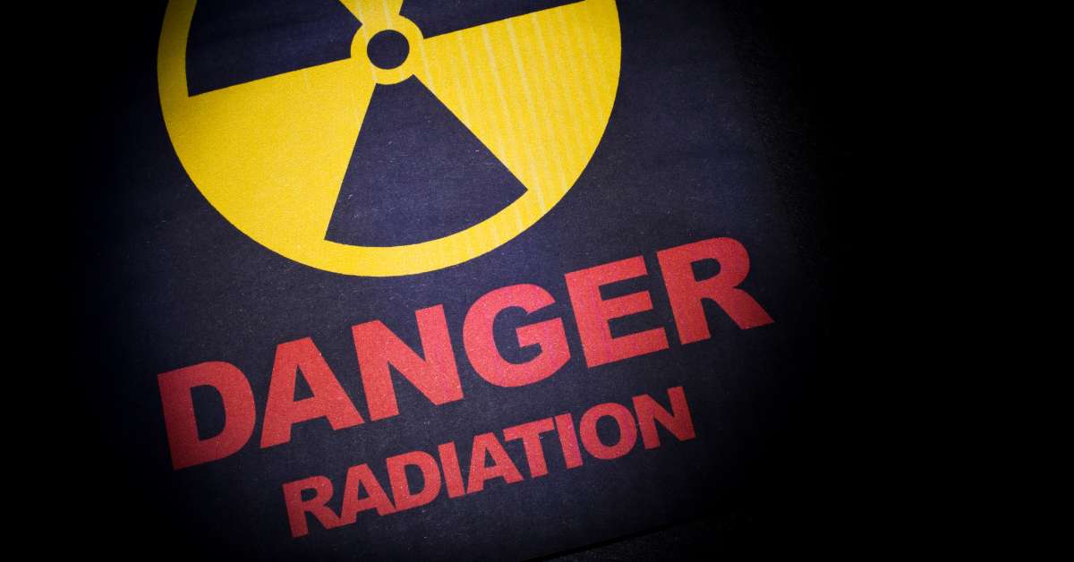 A sign that says "Danger Radiation" in red text with a yellow radiation logo on top. 