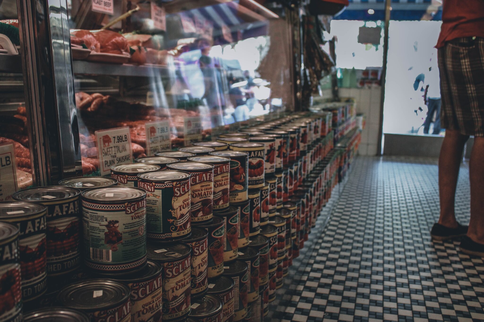 A row of canned goods lined on the floor inside the convenience store. 