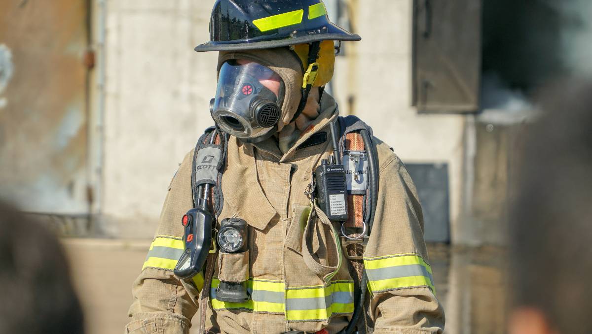 A man in camouflage uniform wearing a respirator mask.