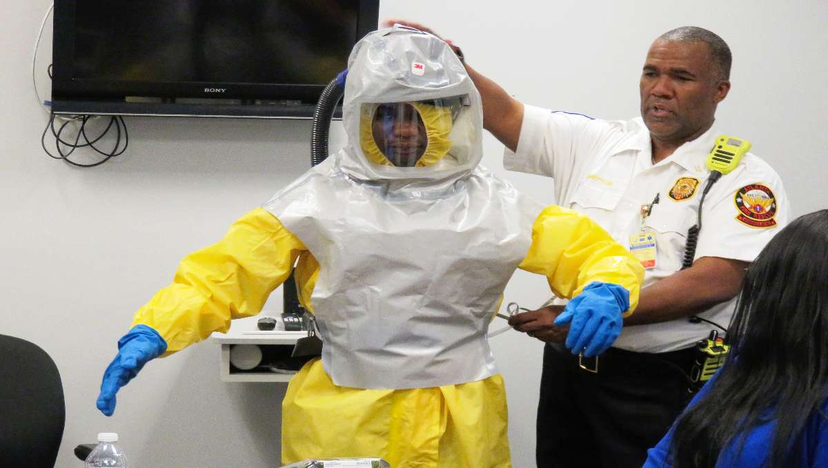 A man in PPE being checked by an officer from CDC.