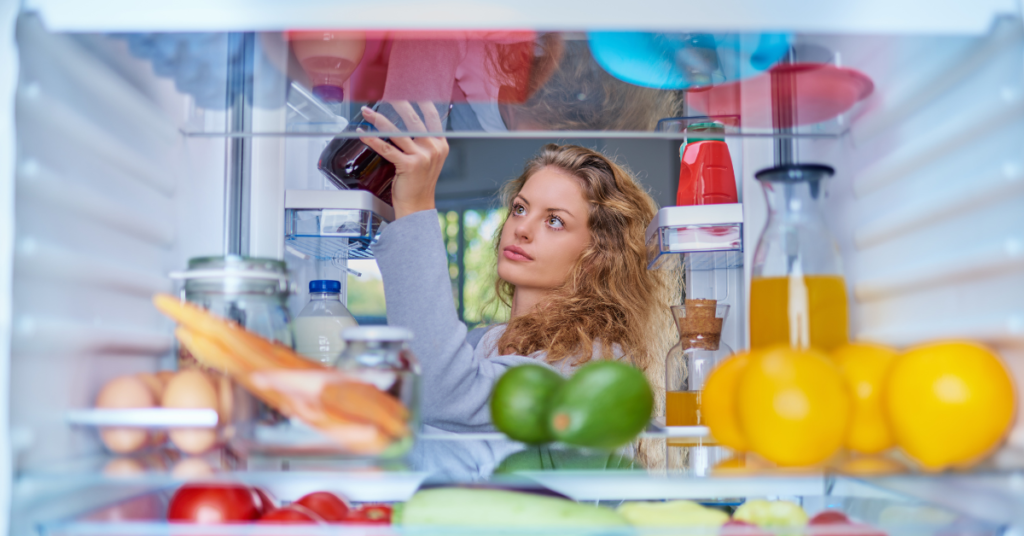 a woman storing food in the fridge