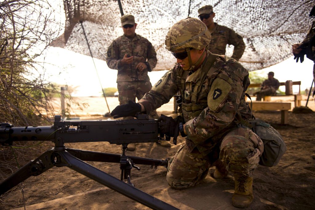 Military men reloading a weapon.