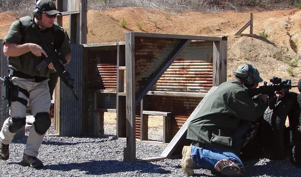 Two military men doing training on how to win a gun fight.