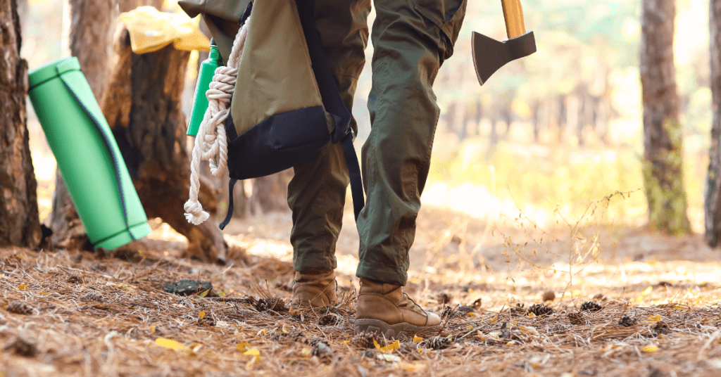 person holding a survival kit and ax